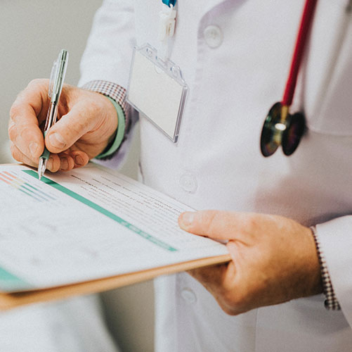 Gros plan d'un médecin qui prend des notes sur un pad