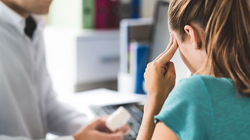 Jeune femme atteinte de migraine dans le bureau du médecin