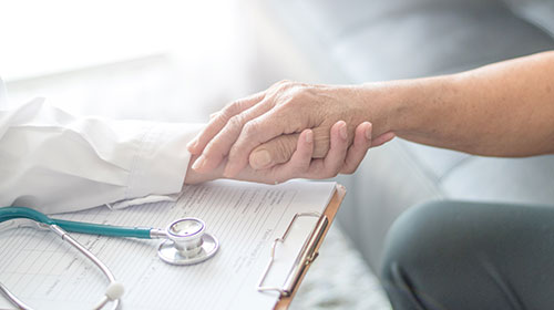 main d'un médecin qui tient celle d'un patient
